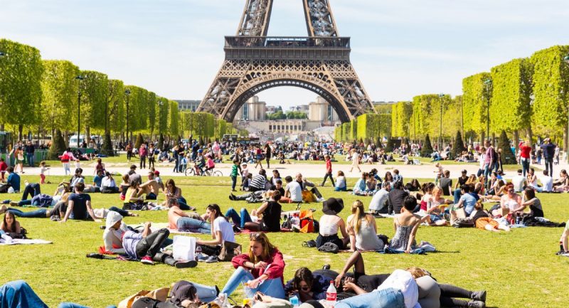 Αμέτρητοι άνθρωποι χαλαρώνουν και διασκεδάζουν καθημερινά στο πάρκο Champ de Mars κάτω από τον Πύργο.